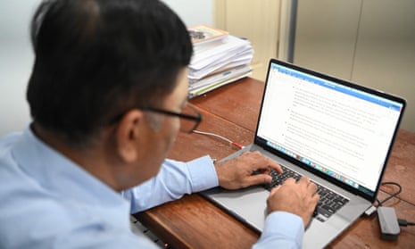 Man in glasses working on laptop at his desk