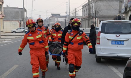 Rescue workers carry an injured person on a stretcher at Dahejia town after the earthquake