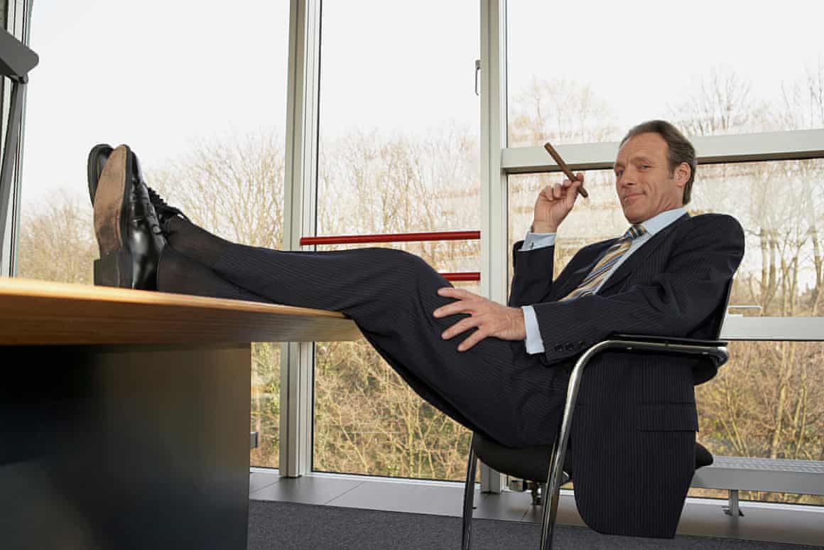 A man in a suit with his feet up on an office table