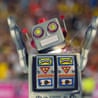 A photo composite of a retro robot running on an athletics track whilst sparks fly from it.
