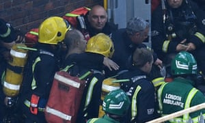 A man is rescued by firefighters after a huge fire engulfed the 24-storey Grenfell Tower.
