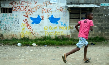 A boy runs near a mural reading ‘Youngsters let’s go for peace’ in Apartado, Colombia, in June 2016. 