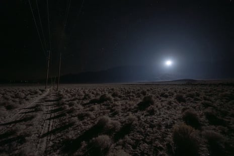 A bright glowing light hovers over a desert plain at night, demonstrating a rescue lighting technology