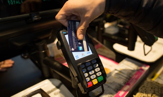 A customer uses a credit card to make a contactless payment.
