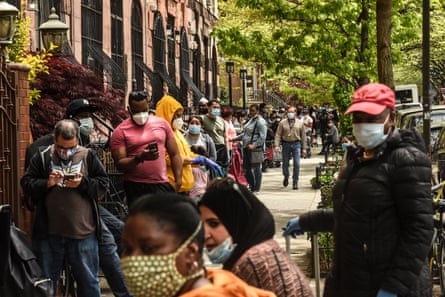 People wait to receive a food bank donation at the Barclays Center sports arena in New York City on 15 May.