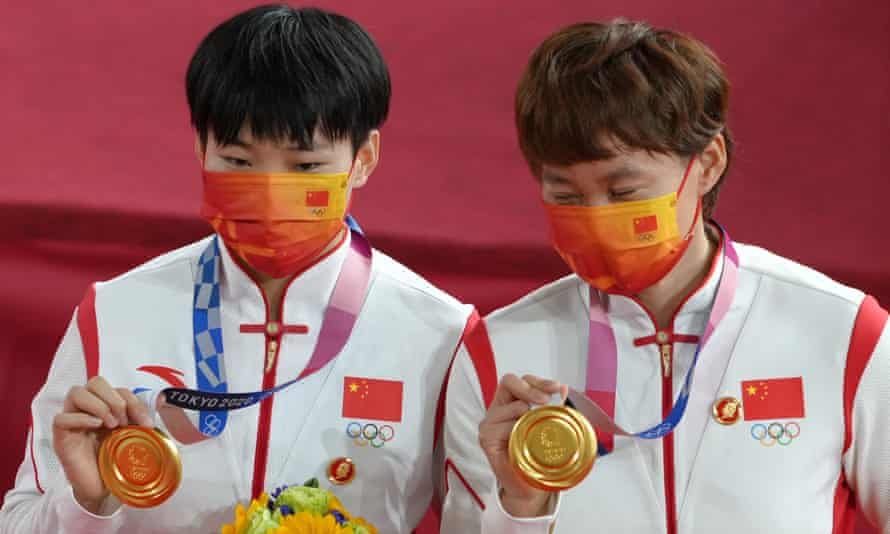 Bao Shanju และ Zhong Tianshi สวมตราของเหมา Zedong ตอนปลายในพิธีมอบเหรียญวิ่งทีมหญิง