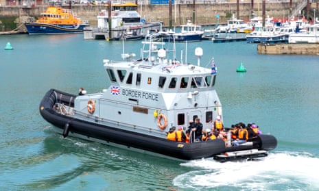 A Border Force boat carrying several people in orange lifejackets at the port of Dover