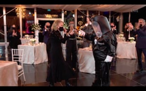 A pressenter dons a hazmat tuxedo to deliver Catherine O’Hara’s award