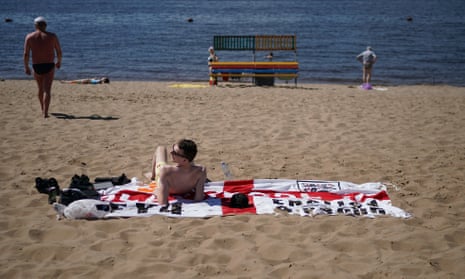 Wish you were here … An England fan sunbathes on the banks of the Volga in Samara the day before the quarter-final against Sweden.