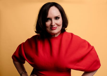 Author and podcaster Deborah Frances-White wearing a red top and smiling at the camera.