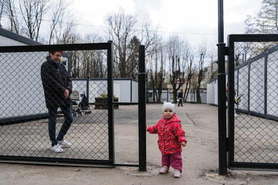 Russia-Ukraine war latest: Ukraine offers unconditional talks on Mariupol as west warns of Russian cyber-attacks – live | Ukraine 2 A woman seen with her granddaughter at the settlement for displaced people.