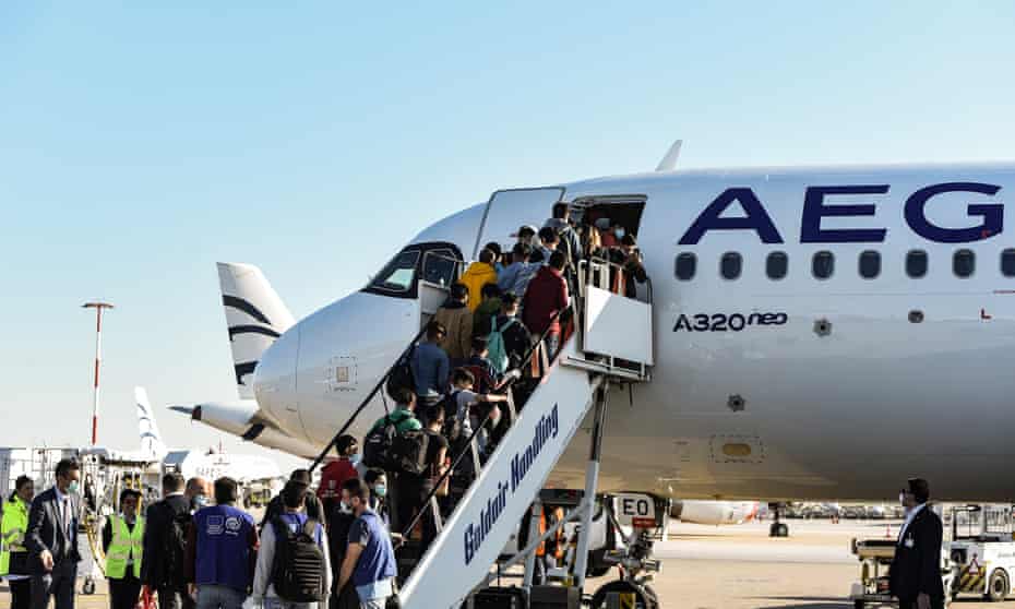 Unaccompanied children board a plane in Athens on their way to shelters in Germany