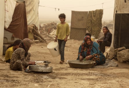 Syrian refugees outside their tents during a sandstorm, in a camp in Lebanon’s Bekaa Valley.