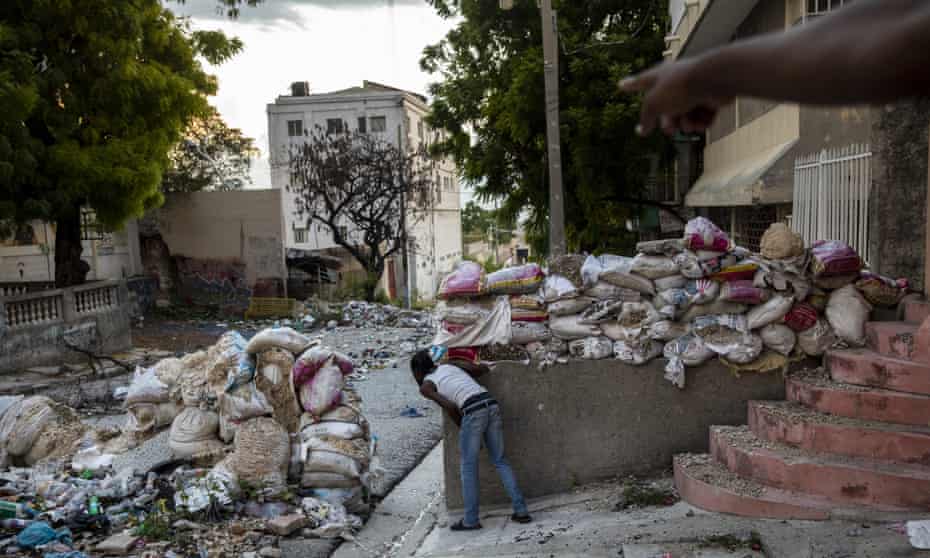 A lookout keeps an eye on rival gangsters in downtown Port-au-Prince, Haiti, in September. At least 165 gangs – many with tacit political backing and support – operate in the country.