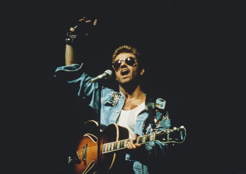 George Michael on stage during the Faith tour, in white vest and denim jacket, 1988.