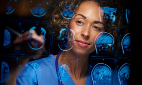 A female doctor analysing digitally generated scans of a human brain