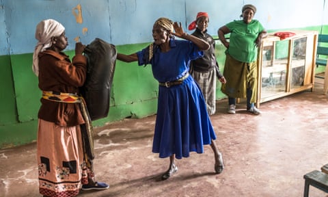 Group leader Beatrice Nyariara (in blue dress) demonstrates a punching technique.