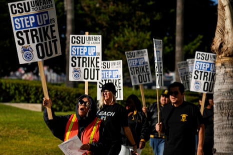 Union members hold signs that read "CSU unfair to labor. Step up or strike out."