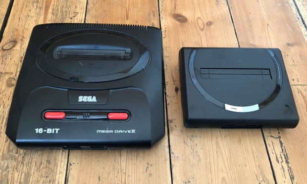 The Analogue Sg photographed next to an original Mega Drive II. The new machine replicates the circular motif around the cartridge port and retrains the headset port in the front