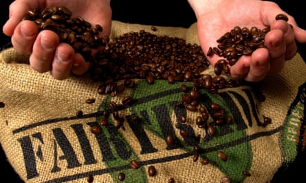 hands holding coffee beans over sack with fairtrade logo