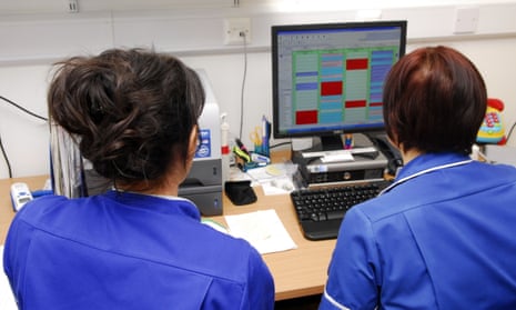 Healthcare workers look at a computer screen