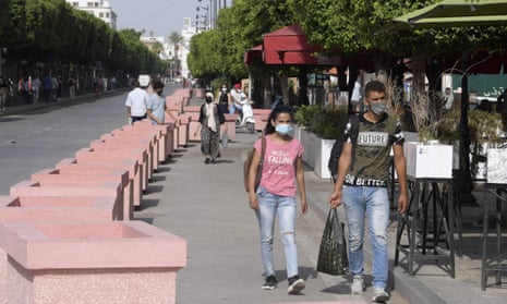 Tunisians walk along Avenue Habib Bourguiba in Tunis on Tuesday
