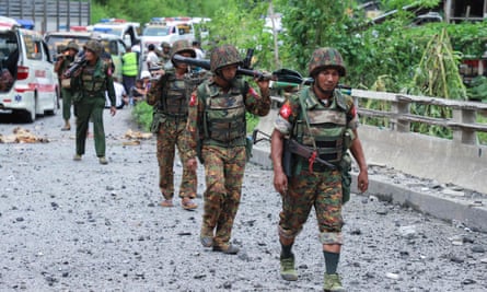 Myanmar troops cross a bomb damaged bridge in Shan State on Thursday after it was attacked by ethnic rebel groups in fighting that has killed at least 14.