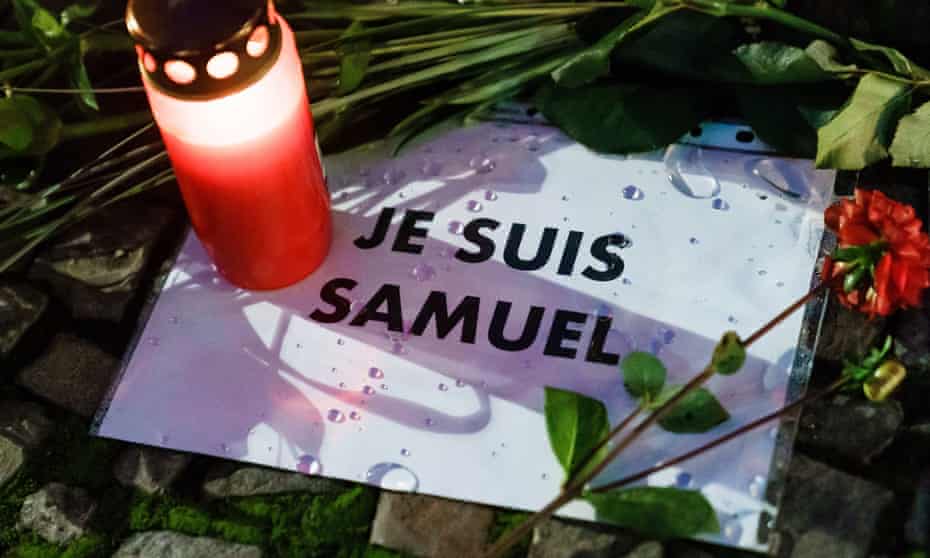 Piece of paper with "Je suis Samuel" written, with a rose and a tealight