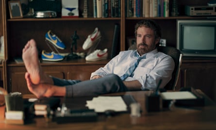 Ben Affleck joue le chef de Nike Phil Knight dans Air.  Il est pieds nus, les pieds sur son bureau.