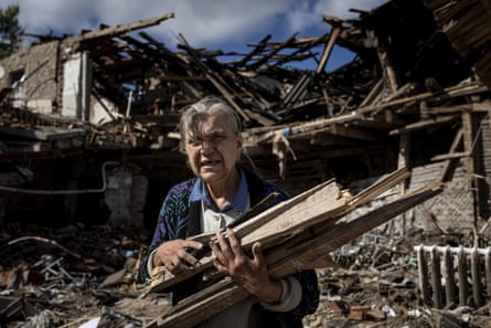 A woman collects wood for heating from a destroyed school where Russian forces were based in Izium, 19 September.