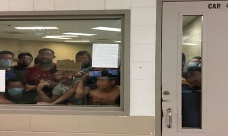 Some of a group of 88 adult males press against the window of a cell built to hold 41 people at Fort Brown border patrol station in Brownsville, Texas.