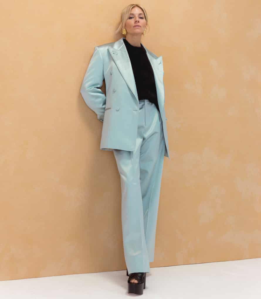 Actor Sienna Miller in turquoise suit against pinky-brown background