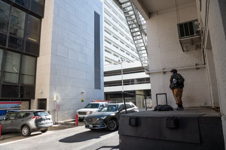 Chris Carver, at his camp, prepares for his day as he watches cars drive into the adjacent office building in downtown Spokane.