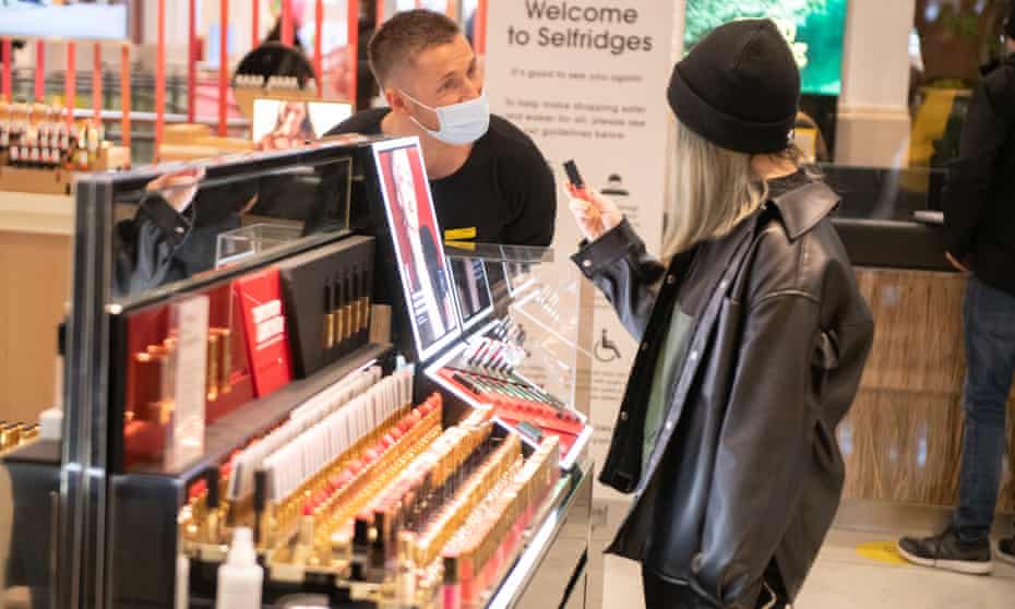 A sales assistant helps a customer in Selfridges in London