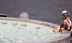 A child dips her feet in a fountain in Rome on Tuesday.