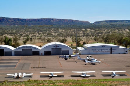 Aircraft outside a number of hangers at an airport on a sunny day.