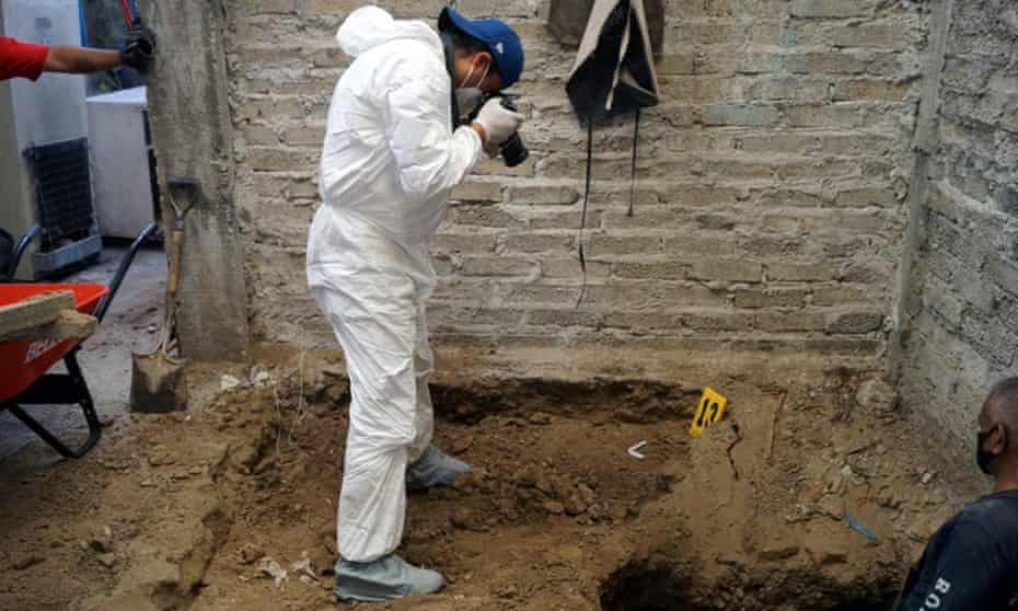 A forensic worker takes a picture of an excavation during an investigation at the house of the alleged serial killer in the municipality of Atizapan de Zaragoza, Mexico state.