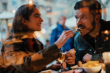 A woman feeding her partner during a romantic dinner.
