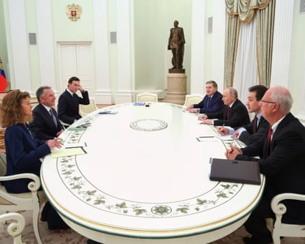 People gathered around a white oval-shaped table at the Kremlin