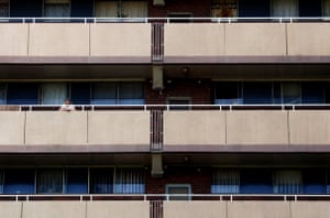 A women standing on a balcony of a Surry Hills housing commission block.
