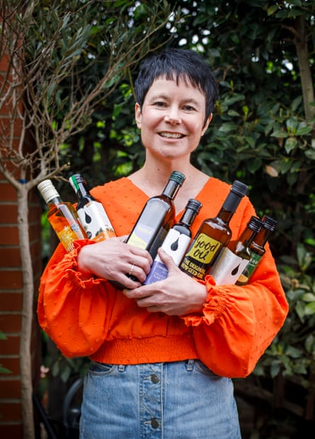 Rachel holding seven bottles of cooking oil in her garden.