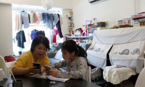 Asa Lai, helps her daughter Caris, 11, with her school work at their home in Hong Kong in September.