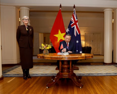 President To Lam signs a visitors’ book at Government House alongside Sam Mostyn