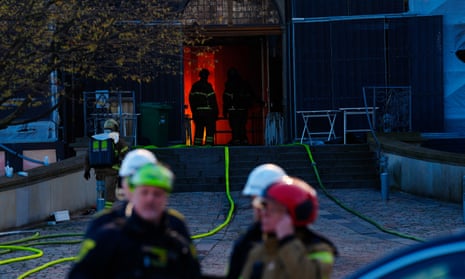 Firefighters work at the main entrance of the historic Boersen stock exchange building which is on fire in central Copenhagen.