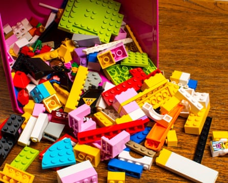A scattering of Lego pieces falling out of a box tipped on its side.