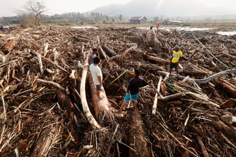 Filipino villagers stand on washed-up logs and debris caused by Typhoon Usagi in the coastal municipality of Santa Ana, Cagayan province