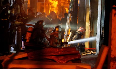 Firefighters work to put out the at an apartment block in Hanoi, Vietnam
