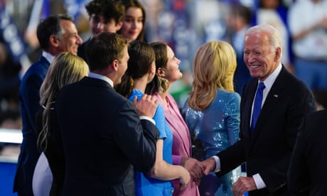 a man in a suit smiling and shaking hands with people
