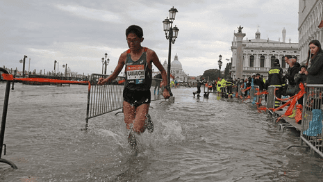 Marathon runners race through Venice's flooded streets – video