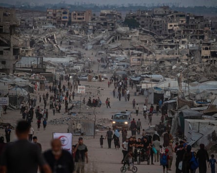 Displaced Palestinians walk amid the rubble in Jabalya, north of Gaza City